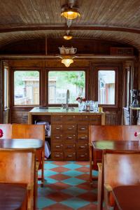 a kitchen with wooden cabinets and a sink and tables at Tyrolens vagnshotell in Alvesta
