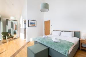 a bedroom with a large bed and a chair at The Lark Ascending BR11 Silverlake Dorset in Warmwell