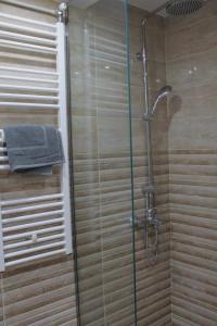 Un baño con ducha con puerta de cristal. en Luxury varkiza apartment, en Vari