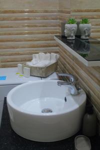 Un baño con un lavabo blanco y un espejo. en Luxury varkiza apartment, en Vari