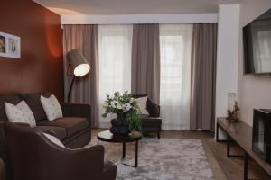 a living room with a couch and a table with flowers at Quality Hotel Grand Falun in Falun +124 photos