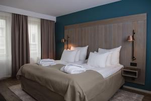 Un dormitorio con una cama grande con almohadas blancas. en Quality Hotel Grand Falun, en Falun