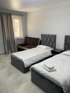a hotel room with two beds and a chair at Erevan palas Apartament in Pʼarakʼar