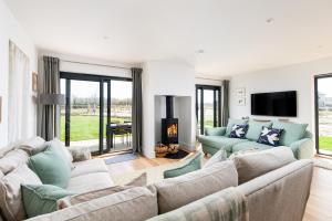 a living room with two couches and a fireplace at Sunday Sun BR31 Silverlake Dorset in Warmwell