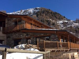 eine Blockhütte mit Terrasse im Schnee in der Unterkunft La Meiro in Castelmagno