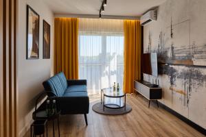 ジェシュフにあるApartament Niebieski Horyzont Kopisto 11 Centrum Miasta Rzeszówのリビングルーム(青い椅子、テレビ付)