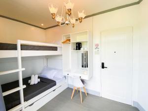 a bedroom with bunk beds and a desk and a chandelier at Ronina's Sipocot Hotel in Sipocot +30 photos