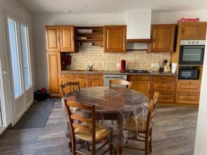 una cucina con tavolo e sedie in una cucina di Saint Pierre de Maillé 86260 Maison a Saint-Pierre-de-Maillé