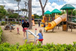 a man and a child playing in a playground at Fabulous village in Casal Palocco