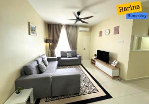a living room with a couch and a tv at Harina Homestay At Sireh Residence near AEON MALL KOTA BHARU in Kota Bharu