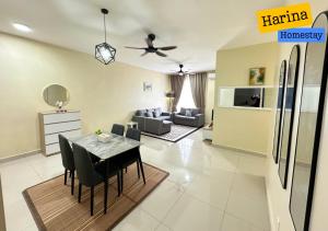 a kitchen and living room with a table and chairs at Harina Homestay At Sireh Residence near AEON MALL KOTA BHARU in Kota Bharu