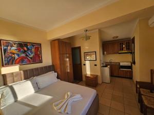 a bedroom with a large bed and a kitchen at Villa Noar in Vlorë