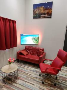 a living room with a red couch and a chair at Stijlvolle Designstudio in Almere
