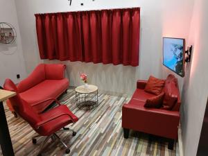 a living room with a red couch and a chair at Stijlvolle Designstudio in Almere