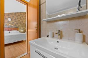 a bathroom with a sink and a bedroom with a bed at Olea Magica Apartments in Rovinj +45 photos
