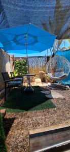 a blue umbrella and a bench and a swing at AN edom suite in Eilat