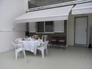 a white table with white chairs and a white umbrella at View Camelias House by SixtyFive Boutique Home in Ericeira