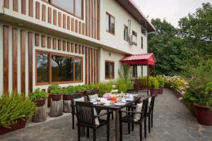 a patio with a table and chairs in front of a building at May Cottage By Rokeby Villas in Mussoorie