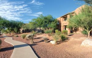 a walkway in a garden with trees and a building at Wyndham Rancho Vistoso in Oro Valley