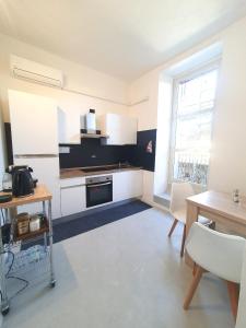 萨萨里Charlie's Apartment -Centro Storico的厨房配有白色橱柜、桌子和窗户