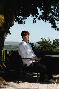 a man sitting on a chair under a tree at Les Hauts de Sancerre in Sancerre +46 photos