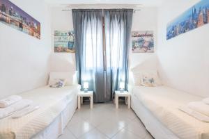 two twin beds in a room with a window at P012 Apartment in Cagliari