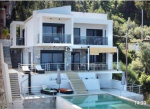 a large white house with a swimming pool at Villa Skalia Lefkada in Athani