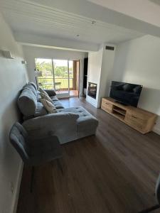 a living room with a couch and a flat screen tv at Maravilloso apartamento en Llívia in Llivia