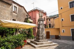 a statue in the middle of a courtyard with an umbrella at B&B Magliuolo in San Giovanni a Piro