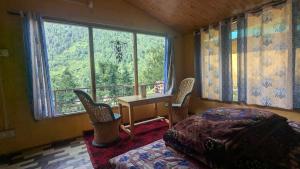 a bedroom with a bed and a desk and a window at Alpine Homes by Kayal Wood in Kulu