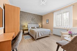 a bedroom with a bed and a desk and chairs at Olea Magica Apartments in Rovinj