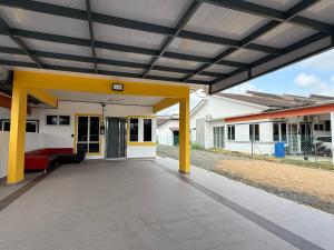 an open porch of a home with a yellow and white house at Chill Inn Homestay in Jerantut