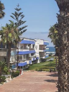 un edificio con palmeras y el océano en el fondo en Appartement Palm Beach - Mansouria, en Pont Blondin
