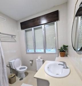 a white bathroom with a toilet and a sink at Casa en el Camino de Santiago en Barro in Barro