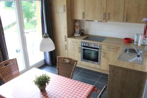 a kitchen with a table and a sink and a stove at Haus Ferientraum in Feldberg