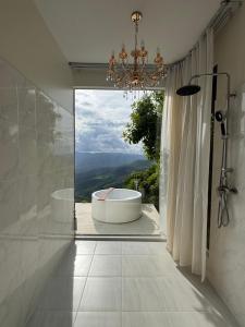 a bathroom with a tub and a large window at Cheevavavee Doichang Chiangrai in Ban San Pu Loei
