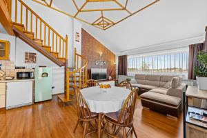 a kitchen and living room with a table and a couch at Olea Magica Apartments in Rovinj