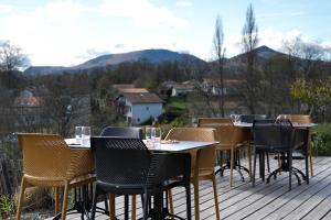 a row of tables and chairs on a deck at Hôtel Restaurant Aldaburua in Larressore