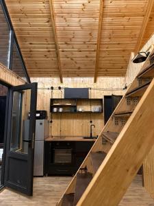 a large kitchen with wooden ceilings and a staircase at Banoja Twins in Kutaisi