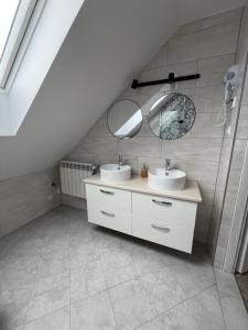 a bathroom with two sinks and a mirror at Przystanek Zator in Zator