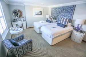 a hotel room with two beds and a chair at Harbour Hotel & Spa Christchurch in Christchurch