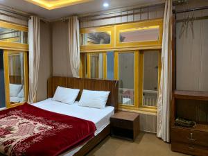 a bedroom with a bed with a red blanket at Alpine Resort Khaplu in Khaplu