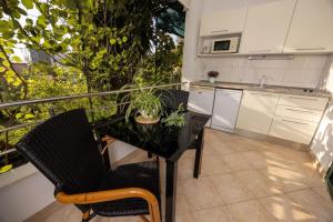 a balcony with a table and chairs and a kitchen at Studio Gita in Promajna +1 photo