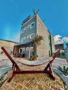 圣路易斯Your Home - Studios Boutique Hotel的建筑物前有一张带吊床的木凳