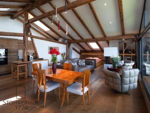 a dining room and living room with a wooden table and chairs at Penthouse am Ammersee bis 4 Personen in Dießen am Ammersee