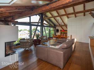 a living room with a couch and a fireplace at Penthouse am Ammersee bis 4 Personen in Dießen am Ammersee
