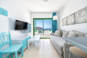 a living room with a couch and a table at Los Veleros Apartments in Puerto Rico de Gran Canaria