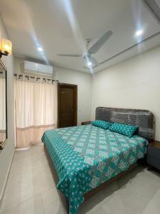 a bedroom with a bed and a ceiling fan at B17 multi garden Islamabad in Dargai
