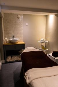 a bathroom with a sink and a bed and a sink at Harbour Hotel & Spa Christchurch in Christchurch