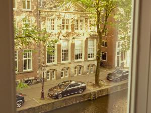 a view of a street with cars parked in front of a building at Sofitel Legend The Grand Amsterdam in Amsterdam